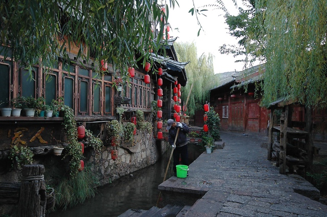 Morgonstädning av kanalerna i Lijiang, Kina.